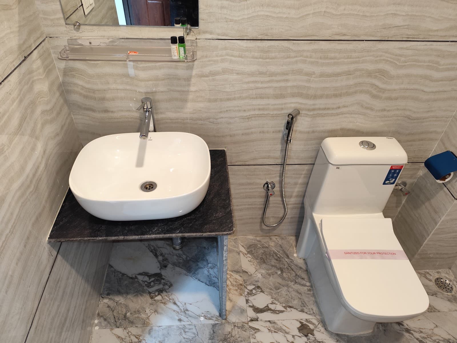 Clean modern attached bathroom with marble tiles at Hotel Greenery View