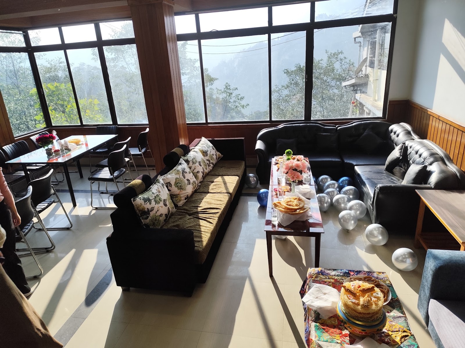 Sunlit mountain view lounge and dining area at Hotel Greenery View Gangtok